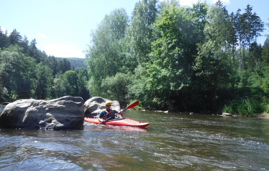 Paddler zwischen Felsbrocken auf der Eger